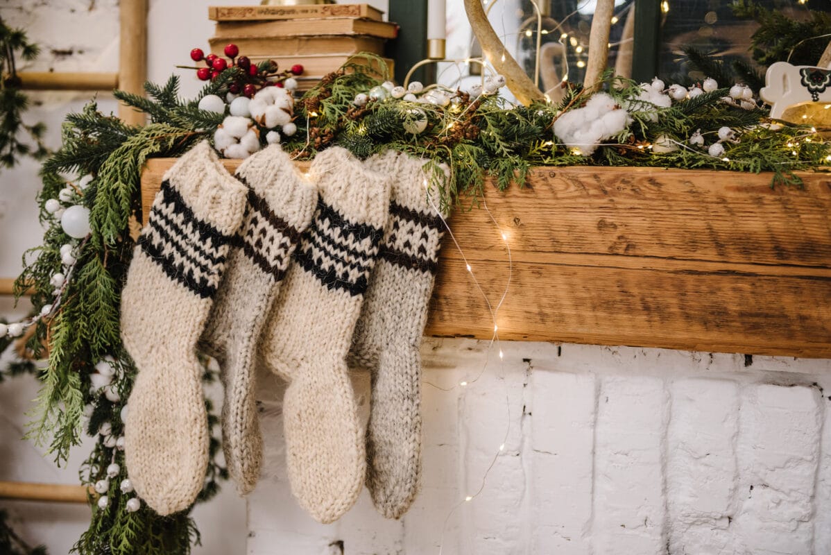 knitted christmas stockings hanging on a fireplace